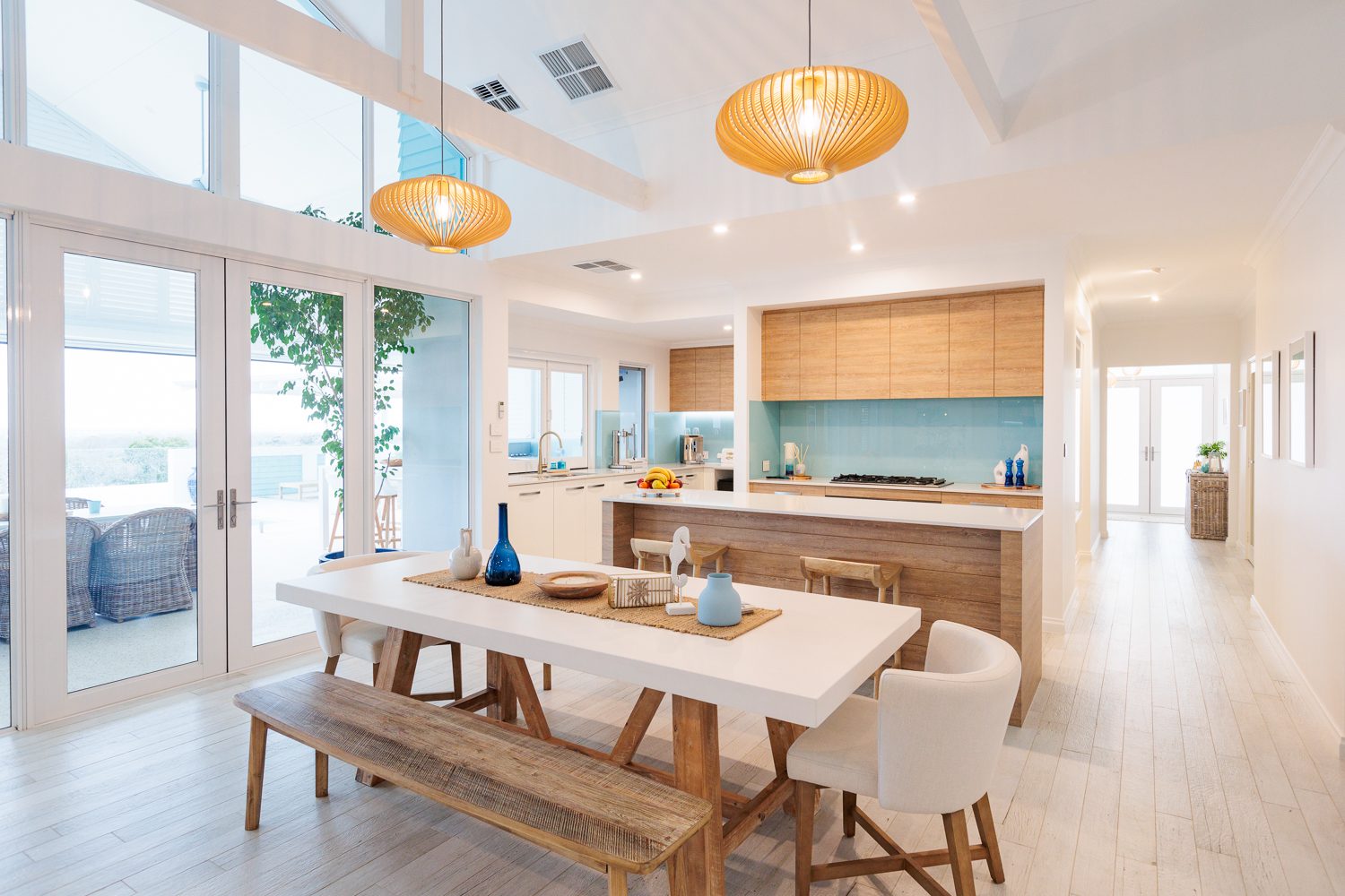 Expansive floor to ceiling windows bathe this custom Airlie Beach design in natural light, creating a welcoming home. Built by WA Country Builders.