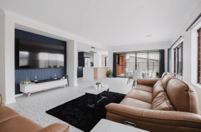 Living area with navy media unit, tan leather recliner and glazing